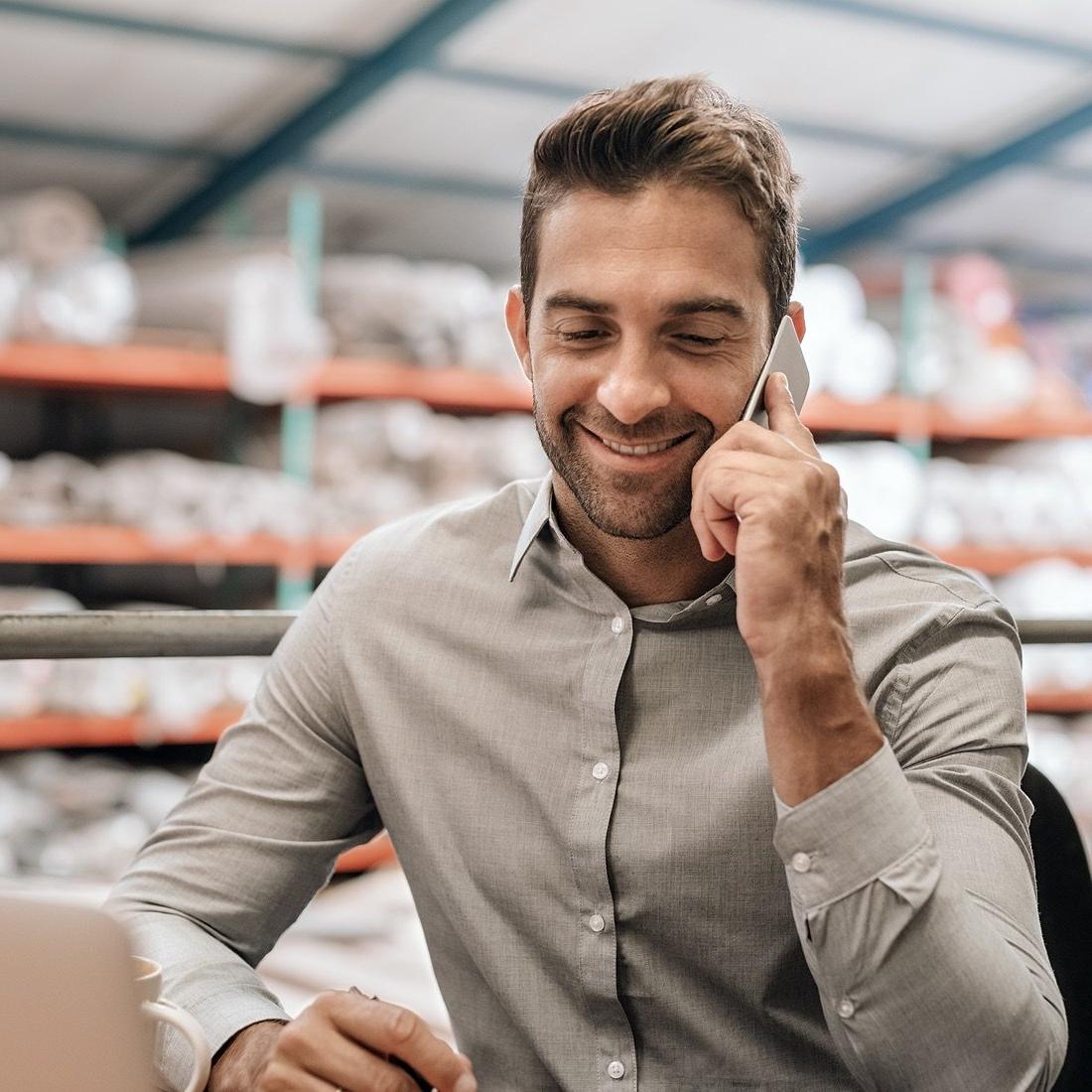 Business owner on phone in warehouse.